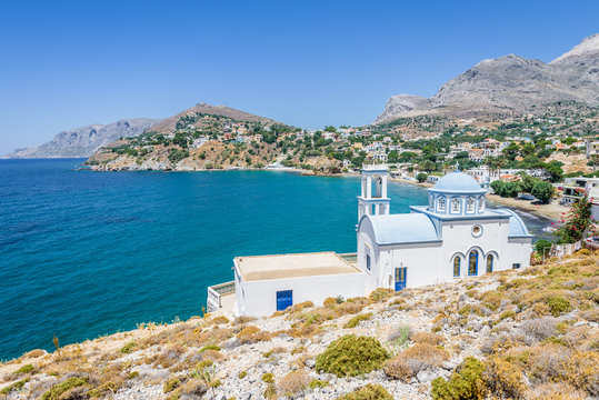 Beautiful white blue greek church monastery Agios Athanasios Timiou Staurou with amazing views to the sea situated in a small greek village Kantouni of Kalymnos Island, Kos Island, Dodecanese, Greece