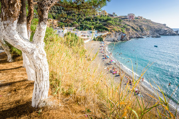 Beautiful sunny holiday view to the greek beach blue sea with crystal clear water beach with some...