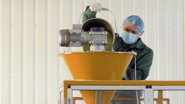 Worker fills the machine with dry tea, tea factory