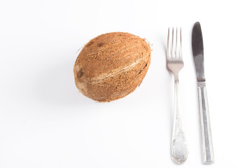 Coconut with a fork and knife. White background.