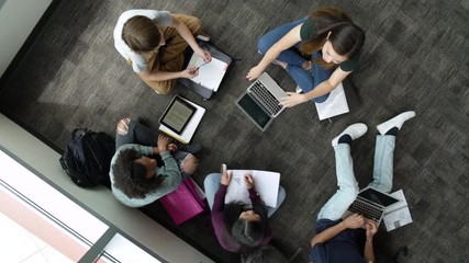 Students talking while studying together on floor