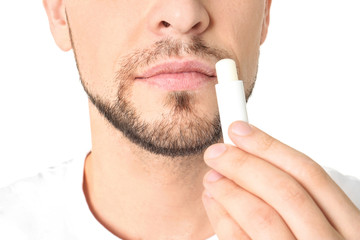 Man applying hygienic lip balm, on white background