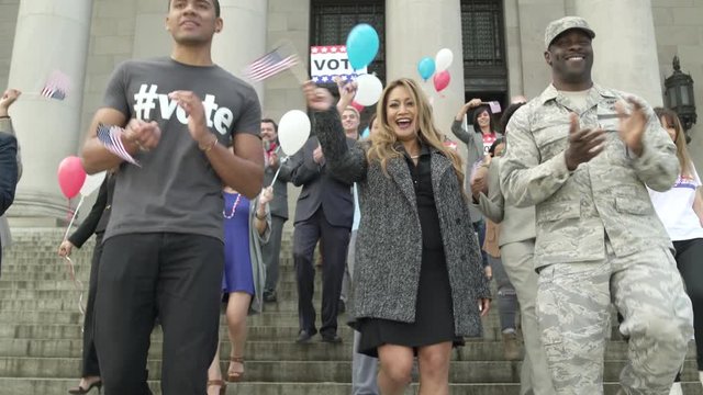 A crowd clapping and applauding while walking down stairs