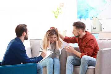 Family psychologist working with young couple in office