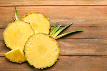 Flat lay composition with fresh sliced pineapple on wooden background