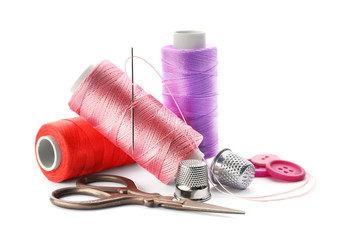 Color threads and sewing accessories on white background