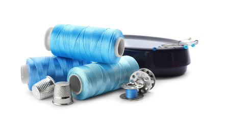 Color threads and sewing accessories on white background