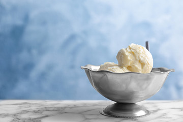 Bowl with tasty vanilla ice cream on table