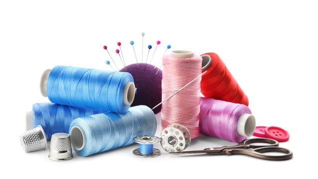 Color threads and sewing accessories on white background