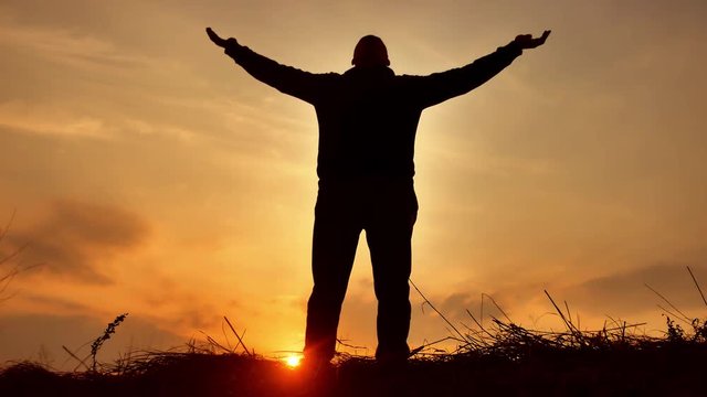 man warrior monk practicing silhouette karate kung Fu on the grassy horizon at sunset. Karate kick leg. Art of self-defense. Silhouette on a background of dramatic clouds at sunset nature lifestyle