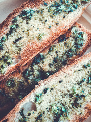 Toasts with basil and garlic close-up on a plate.