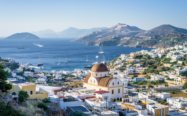 Beautiful mediterranean greek village Pantelis sourrounded by a mountain with ancient castle located at the aegean sea with colorful houses and lovely churches basilicas, Leros, Dodecanese, Greece - obrazy, fototapety, plakaty