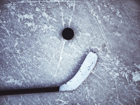 hockey puck and stick laying on the textured ice close up copyspace
