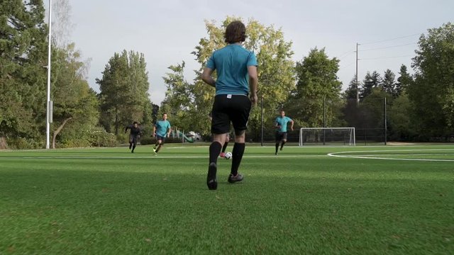 Male soccer players playing soccer.
