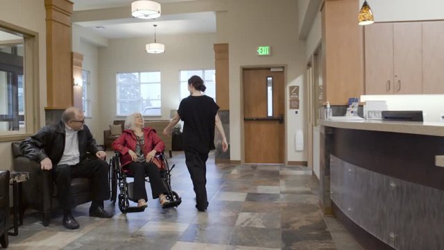 Steadicam shot of a nurse pushing a senior woman in a wheelchair