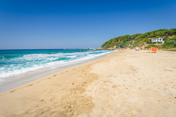 Sunny beautiful summer beach coast view to the greek blue sea white pure sand perfect for holiday relaxing swimming playing , Ikaria Island, Livadhi Beach, Messakti Beach, Armenistis , Sporades,Greece