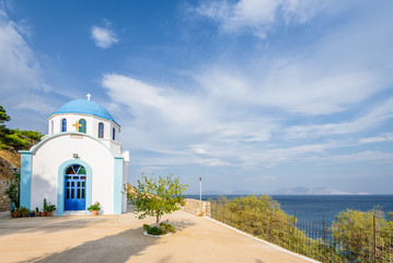 Fototapeta na wymiar Beautiful blue white greek church basilica chapel in the middle of a small greek mountain village with views to mediterranean sea on the island of Ikaria, Agios Kirykos, Sporades, Greece