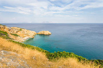 Beautiful sunny summer coast view to the greek blue sea with crystal clear water relaxing holiday beach perfect for sunbath at the shore with a small rock, Agios Kirykos, Ikaria, Sporades, Greece 