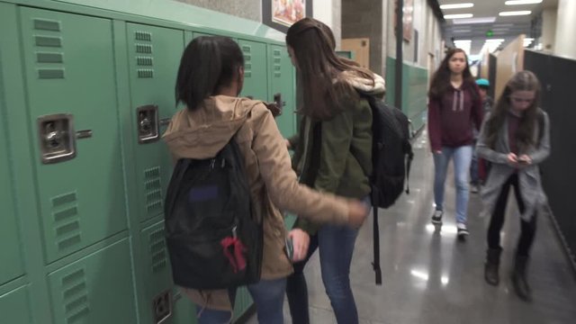 Full shot of two friends meeting on school corridor