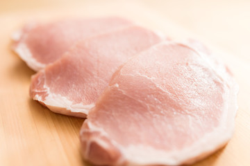 Raw sliced of pork on wooden plate