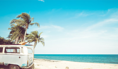 vintage car parked on the tropical beach (seaside) with a surfboard on the roof - Leisure trip in...