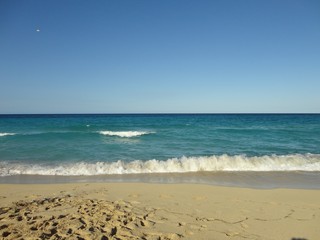Fototapeta na wymiar Playa Tarara Cuba con cielo y mar azul, su espumoso oleaje y una fina arena.