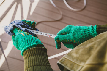 Hands in gloves wipe tape of  large tape measure