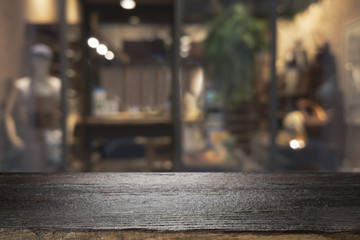 Wooden table with blur background of coffee shop.