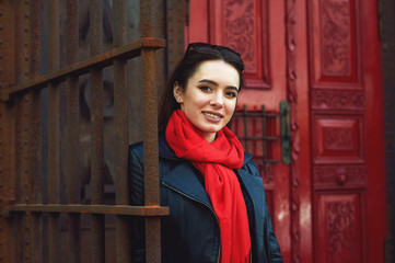 Portrait of a young beautiful woman, girl posing on the streets of a European city . The model is dressed in a stylish leather jacket