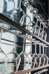 Wine glasses hang up side down on the steel rack. Ready for use.