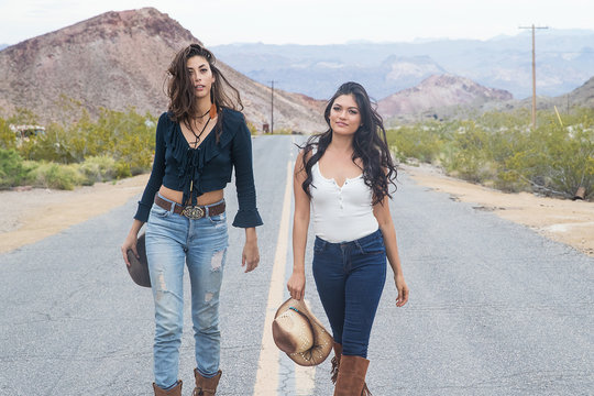 Two pretty country girls on a quiet road in the desert