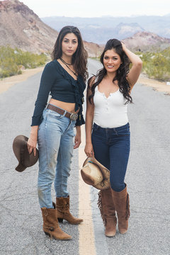 Two pretty country girls on a quiet road in the desert