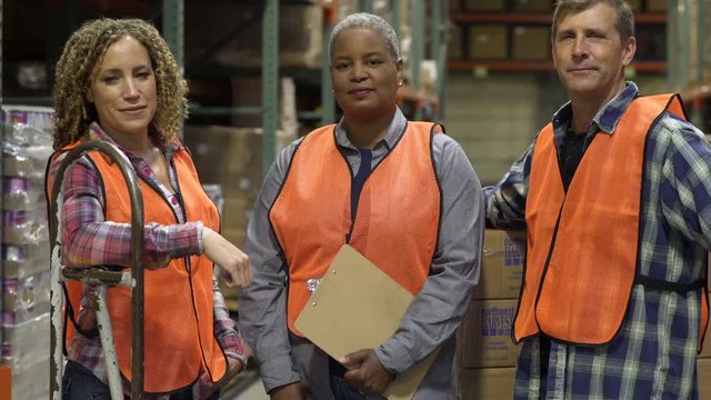 Three workers standing in a warehouse