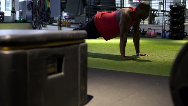 Young man doing push-ups in a gym