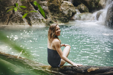 Fototapeta premium Beautidul woman at a waterfall