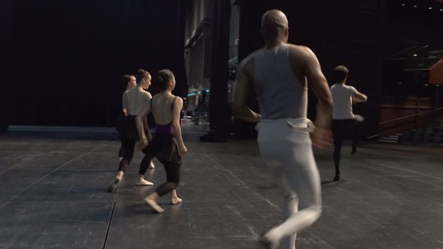 Group of young dancers rehearsing on stage.