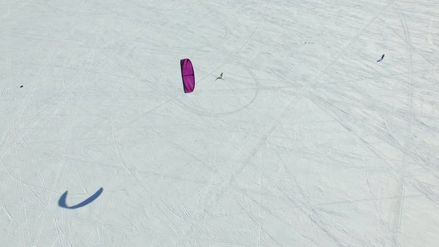 Aerial view:  Powered paragliding ppg flying high above frozen sea.