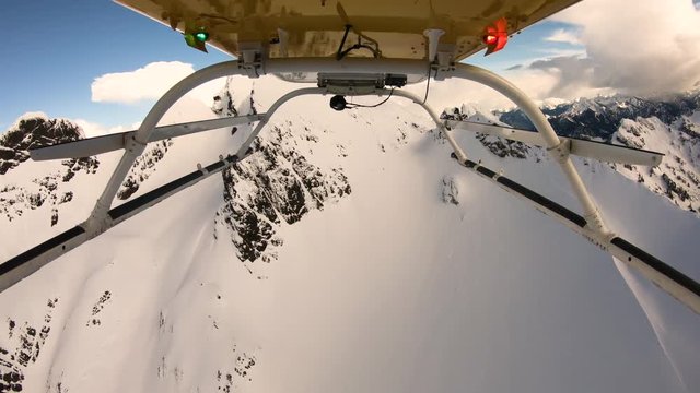 Aerial Flying in Helicopter Above Snow Covered Winter Wonderland Mountain Glacier