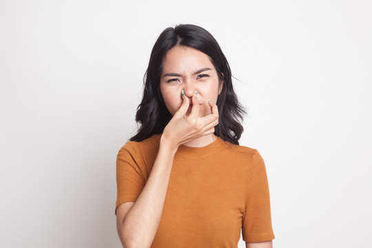 Young Asian woman  holding her nose because of a bad smell.