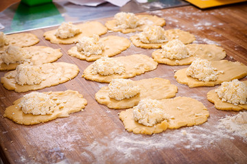 A close-up of the process of cooking buns with cheese on a wooden table