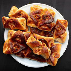 Buns with raisins and jam on a black background