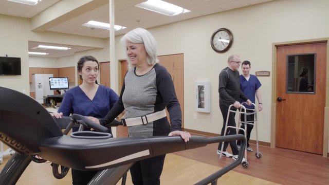 Medium shot of a senior woman walking on a rehabilitation treadmill