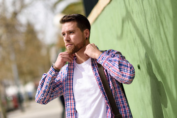 Attractive young man standing in urban background. Lifestyle concept.