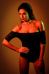 Young brunette woman in black lingerie with red and green lighting