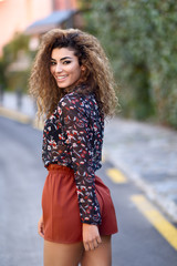 Naklejka premium Happy young arabic woman with black curly hairstyle.