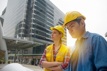 Team of architectures standing at construction site looking at progress.