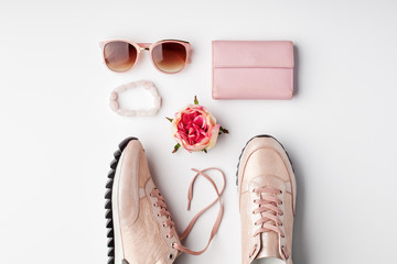 Flat lay pink feminine accessories on white background.