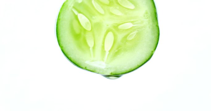 water or oils dropping on a cucumber slice , fruit for diet and healthy food