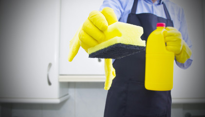 man with scourer and cleaning products cleaning the house