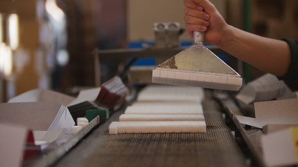 Worker takes sugar from production line at the sugar refinery